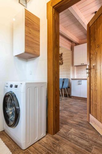 a washer and dryer in a room with a kitchen at Domki Gorczański Zakątek - Jacuzzi in Nowy Targ