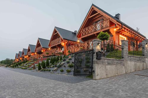 a row of wooden houses with lights on them at Domki Gorczański Zakątek - Jacuzzi in Nowy Targ