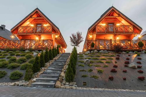 a large wooden house with stairs leading to it at Domki Gorczański Zakątek - Jacuzzi in Nowy Targ