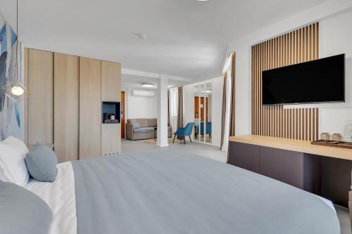 a hotel room with a bed and a flat screen tv at Hotel Laurentum in Tučepi