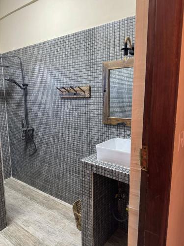 a bathroom with a sink and a mirror at Peace And Color Limited Guest House in Nungwi