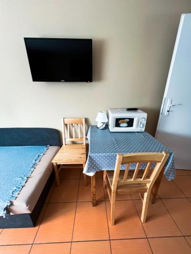 a room with a table and a tv on the wall at Apartman Taktik in Veľký Meder