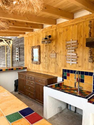 - une cuisine avec des murs en bois, un évier et un comptoir dans l'établissement La Belle de Thau !, à Sète