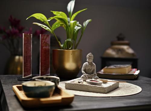 a table with a statue of a buddha and other items at Hotel Bohemia in Františkovy Lázně
