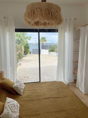 une chambre avec un grand lit avec une grande fenêtre dans l'établissement La Belle de Thau !, à Sète