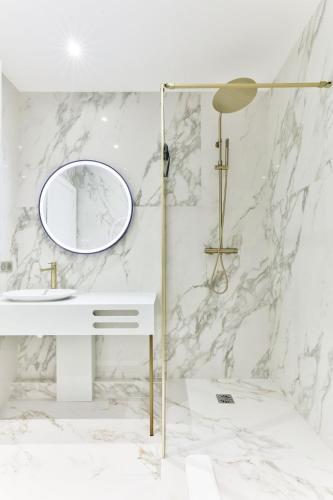 une salle de bain blanche avec un lavabo et un miroir dans l'établissement Family Retreat - Le Marais - with AC, à Paris