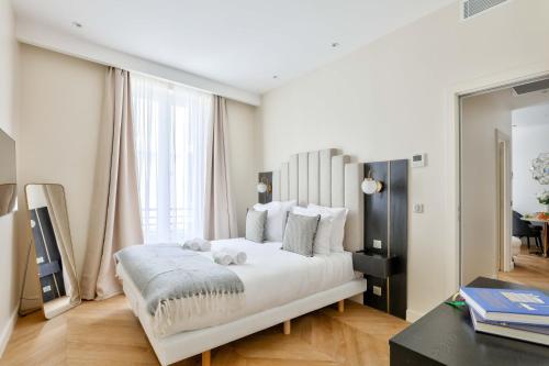 une chambre avec un grand lit blanc et un bureau dans l'établissement Family Retreat - Le Marais - with AC, à Paris