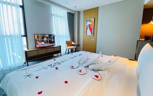 a bedroom with a white bed with roses on it at SIHA Hotel & Casino in Sihanoukville