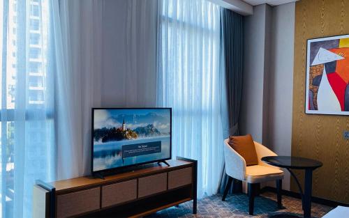 a hotel room with a television and a chair at SIHA Hotel & Casino in Sihanoukville