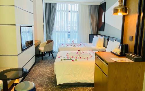 a hotel room with two beds with flowers on them at SIHA Hotel & Casino in Sihanoukville