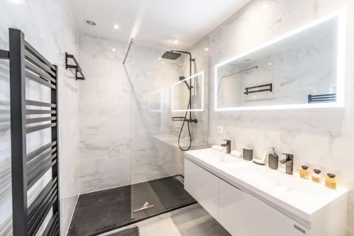 une salle de bain blanche avec une douche et un lavabo dans l'établissement Très beau Duplex 125 m2 hypercentre Lyon 2ème, à Lyon