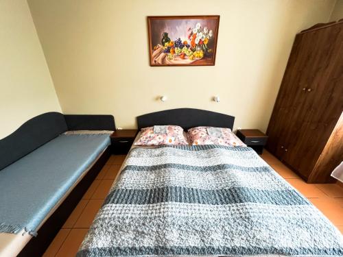 a bedroom with a bed and a picture on the wall at Apartman Taktik in Veľký Meder