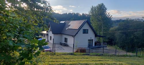 a house with a solar panel on the roof at WILLA NA WYŁĄCZNOŚĆ 12 os BIESZCZADY z Salą Imprezową, Jacuzzi, Sauną, Balią Zewnętrzną oraz 2 baseny z podgrzewaną wodą - Rezydencja Matiaszówka in Polańczyk