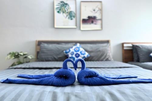 two blue towel swans sitting on top of a bed at Grand Sansook Omnoi in Ban Khlong Om Noi
