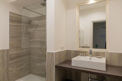 a bathroom with a sink and a mirror at Mosella Suite Hotel in Sottomarina