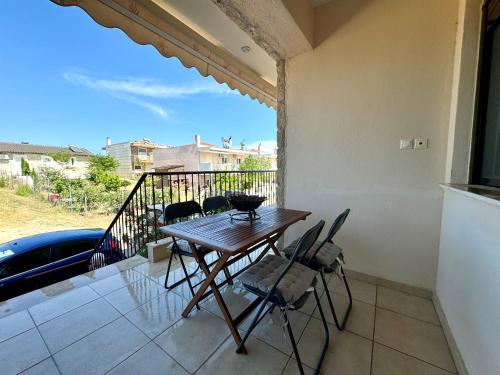 a table and chairs on the balcony of a house at Heliophilia 3-bdrm Maisonette in Nea Fokea in Nea Fokea