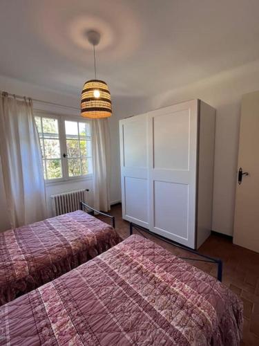 une chambre avec deux lits et une grande fenêtre dans l'établissement Villa avec piscine, à Fréjus