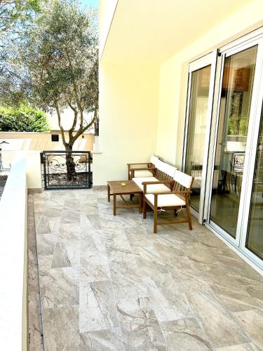a patio with benches on the side of a building at Delux 4 Stars Apartment Ariadne - 1 Min from Beach in Soline