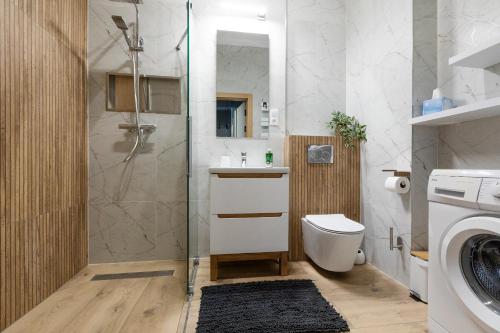 une salle de bains avec douche, toilettes et lavabo dans l'établissement Resort Hevenia Mrzeżyno - Apartament 1, à Mrzeżyno