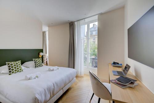 une chambre avec un lit et un bureau avec un ordinateur portable dans l'établissement Stunning Family Flat - Grands Boulevards - with AC, à Paris