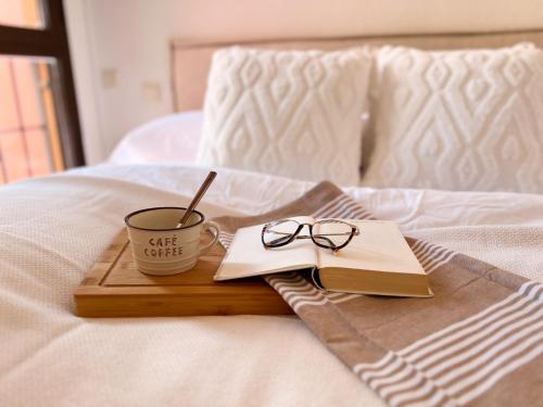 a tray with a coffee cup and glasses on a bed at FuensalidaHomes201 in Fuensalida