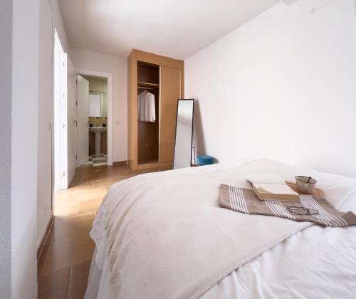 a bedroom with a white bed with two books on it at FuensalidaHomes201 in Fuensalida