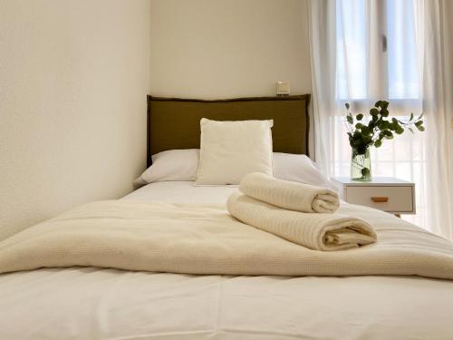 a bed with two towels on it with a window at FuensalidaHomes201 in Fuensalida