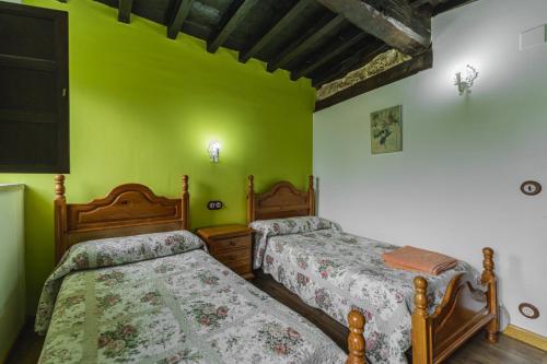 two beds in a room with green walls at Cortijo las monjas in Villaescusa de las Torres