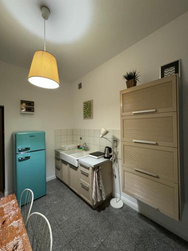 eine Küche mit einem blauen Kühlschrank und einer Spüle in der Unterkunft Apartament Pastelowy in Krynica Morska