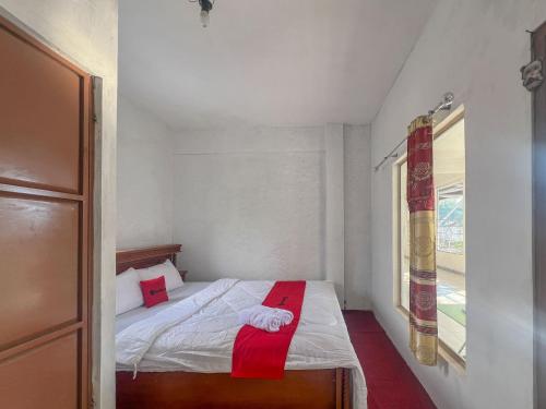a small bedroom with a bed with a red towel on it at RedDoorz Syariah at Jalan Dieng 4 in Kejajar