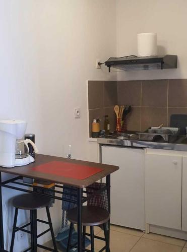 - une cuisine avec une table et quelques tabourets dans l'établissement Nid doux au coeur de grasse, à Grasse