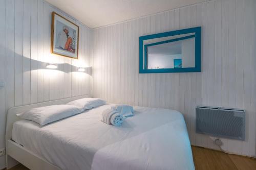 - une chambre avec un lit blanc, un miroir et une télévision dans l'établissement Chamonix Sud - Jonquilles 217 - Happy Rentals, à Chamonix-Mont-Blanc