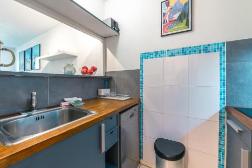 - une cuisine avec un évier et un miroir dans l'établissement Chamonix Sud - Jonquilles 217 - Happy Rentals, à Chamonix-Mont-Blanc