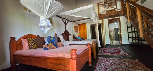 a bedroom with two beds with curtains on them at Salama & Mbuyuni Bungalows in Matemwe