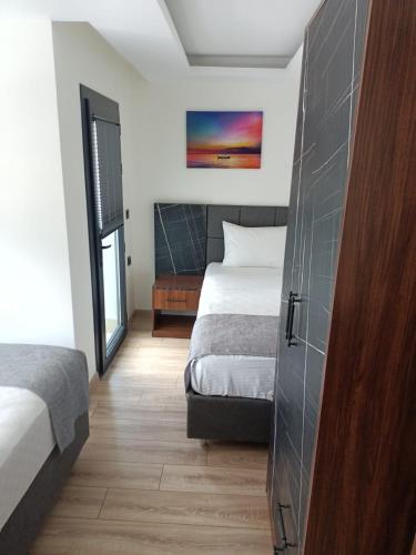 Un dormitorio con una cama y una ventana y una puerta. en White Pearl Residance, en Trabzon