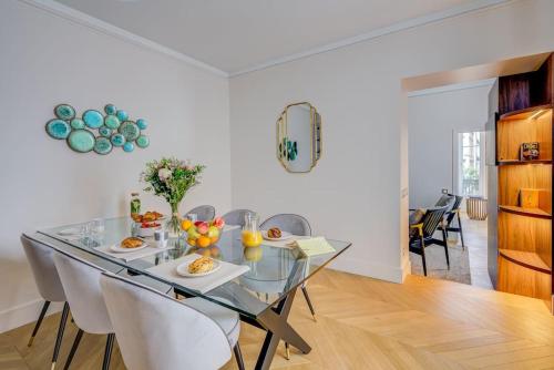 une salle à manger avec une table et des chaises en verre dans l'établissement Elegant family apartment - REX - With AC, à Paris
