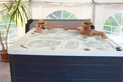 a man and a woman in a hot tub at Moinho da Capela in Campo Maior