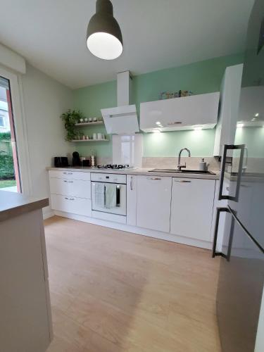 une cuisine avec des armoires blanches et un évier dans l'établissement Bhangah - Verdure et Tranquillité, à Metz