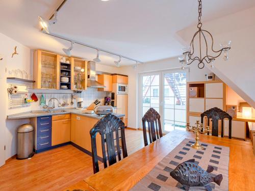 een keuken en eetkamer met een tafel en stoelen bij Haus Kormoran, Fewo Nr 9 in Zingst