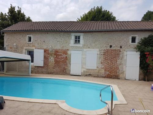 une grande piscine devant une maison dans l'établissement Maison longère La Grange, à Marsac-sur-lʼIsle