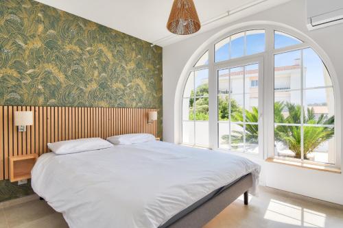a bedroom with a large bed with a large window at Vue mer - Séjour à deux pas de la plage in La Barre-de-Monts