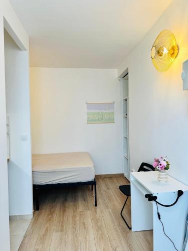 une petite chambre avec un lit et un bureau dans l'établissement Dream Dwell Paris - Flat 800m to Champs de Mars, à Paris