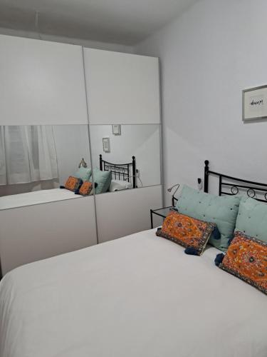 a bedroom with two beds and a large mirror at Ole triana in Seville