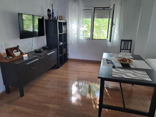 a living room with a table and a television at Ole triana in Seville