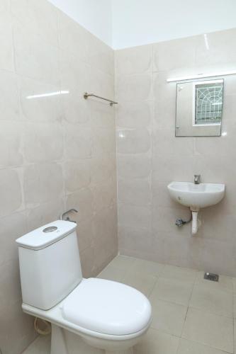 a white bathroom with a toilet and a sink at Greams Road Near Apollo Deluxe Fusion Serviced Apartments in Chennai