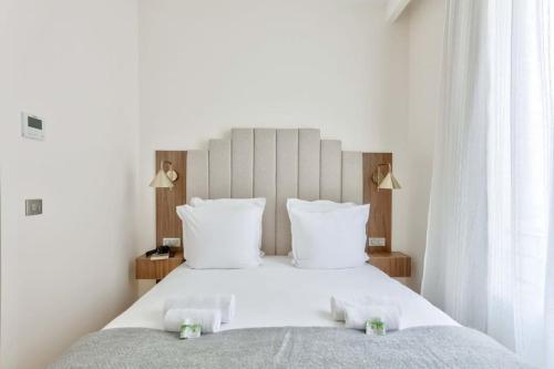 - une chambre avec un grand lit blanc et des oreillers blancs dans l'établissement Luxurious & Peaceful - Near Le Marais - with AC, à Paris