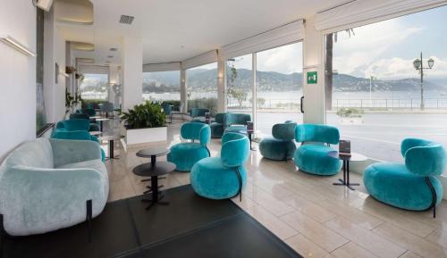 a waiting room with blue chairs and tables at Best Western Regina Elena in Santa Margherita Ligure
