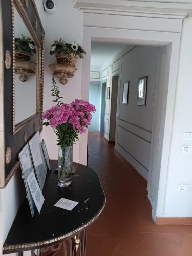 a vase of flowers on a table in a hallway at Foresteria San Niccolò in Prato