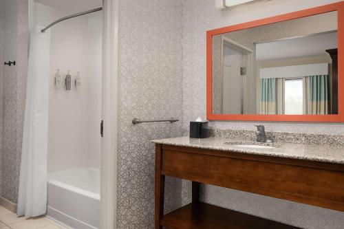 a bathroom with a sink and a tub and a mirror at Hampton Inn & Suites Huntsville Research Park Area in Huntsville