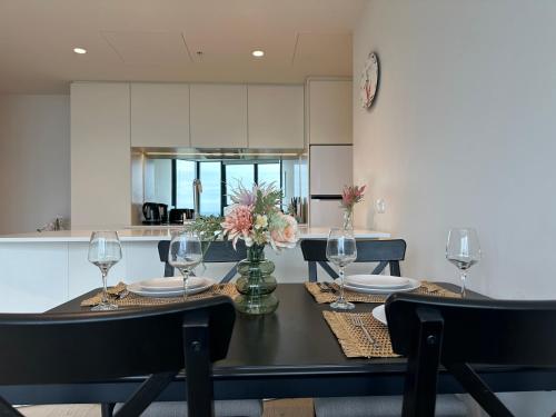 a dining room table with wine glasses and flowers on it at Skyline Serenity Retreat in Melbourne